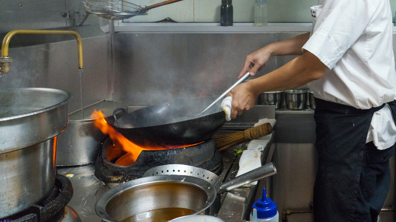 A wok cooking over an open flame