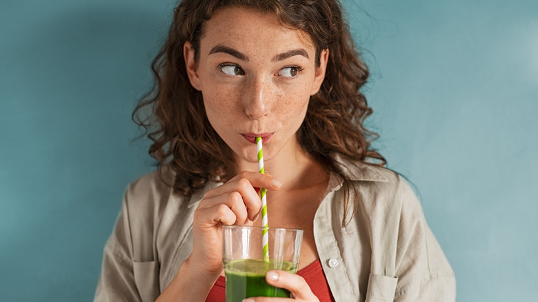 person drinking green juice