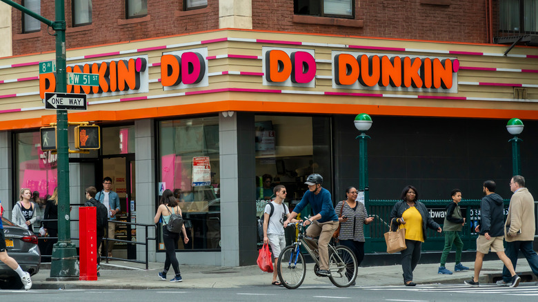 Pedestrians walking in front of a New York City Dunkin'