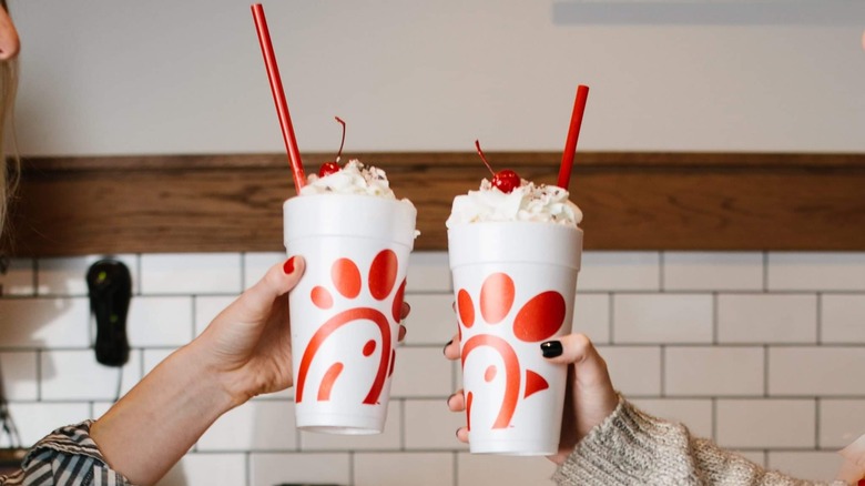 Two people toasting Chick-Fil-A milkshakes