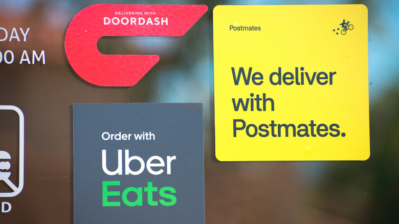 logos of food delivery apps on a window