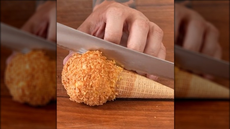 TikToker Andy Hearnden cutting a deep fried ice cream cone in half.