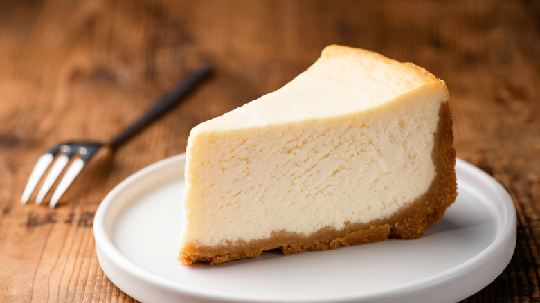 Slice of cheesecake on dessert plate with fork