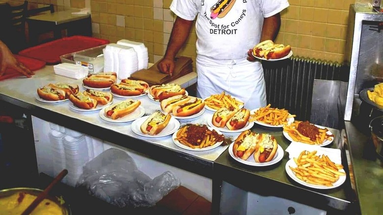 Lafayette Coney Island employee serving hot dogs and fries