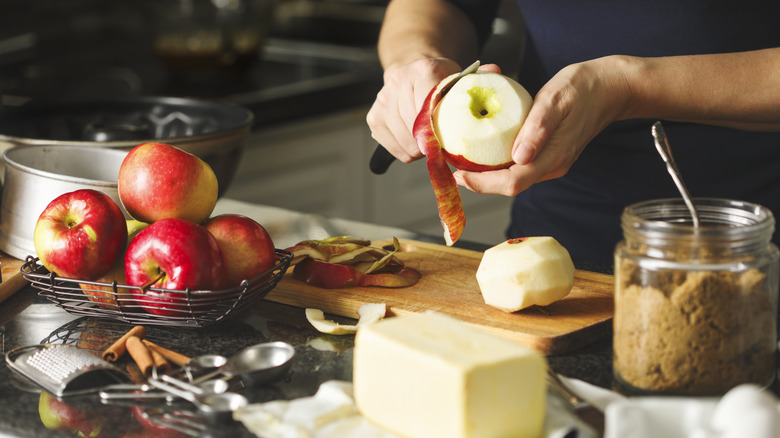 person peeling apples, baking supplies