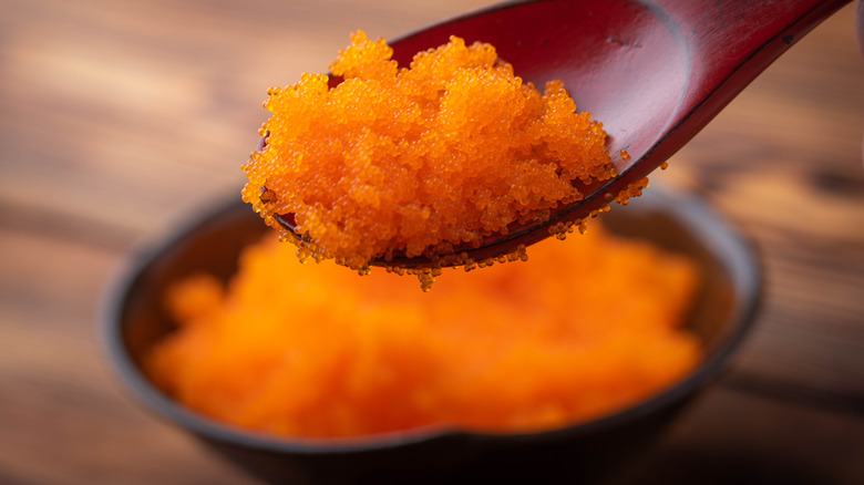 Orange tobiko on a wooden spoon 