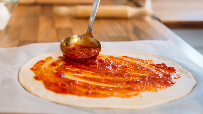 Pizza sauce spread on dough