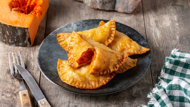 Pumpkin empanadas on a wooden plate