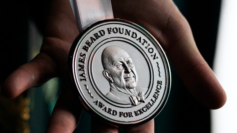 Hand holding James Beard medal