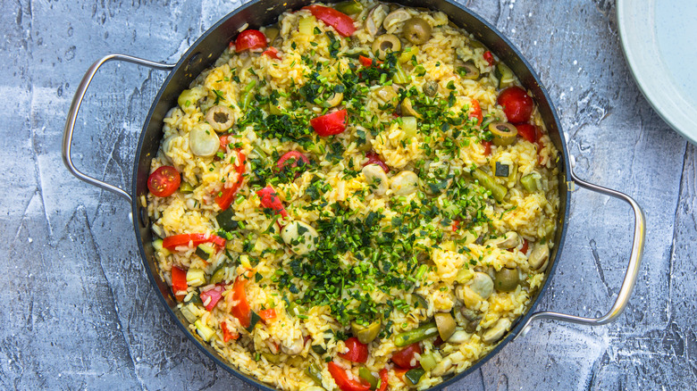 Vegan paella in pan on gray background