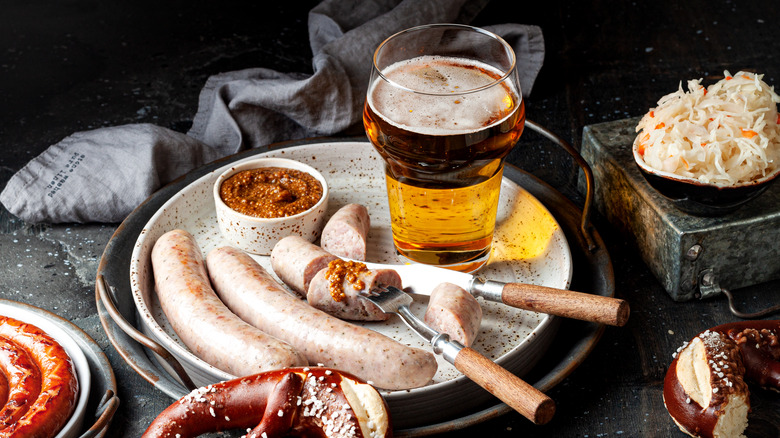 Weisswurst on a plate with a glass of beer and pretzel