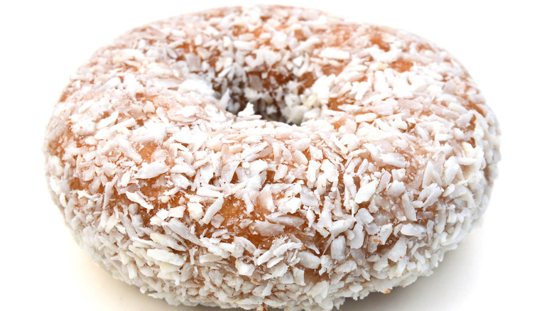 Coconut covered donut on white background