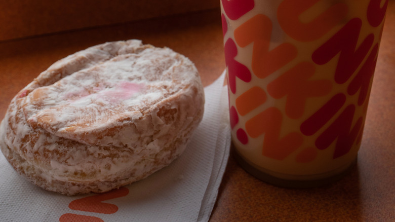 Jelly donut on Dunkin' Donuts napkin next to DD cup