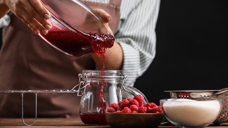 Woman pouring raspberry jam 