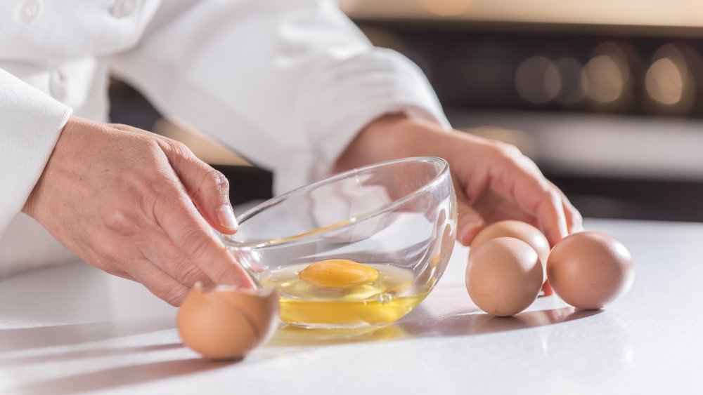 Chef with bowl of eggs that have been cracked