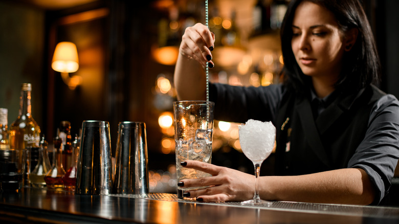 Bartender stirring spirit in ice