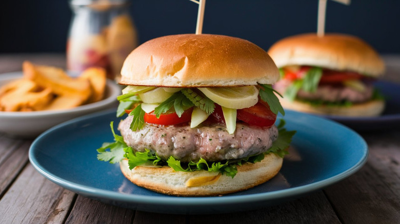 Turkey burger with tomato, herbs, and other toppings