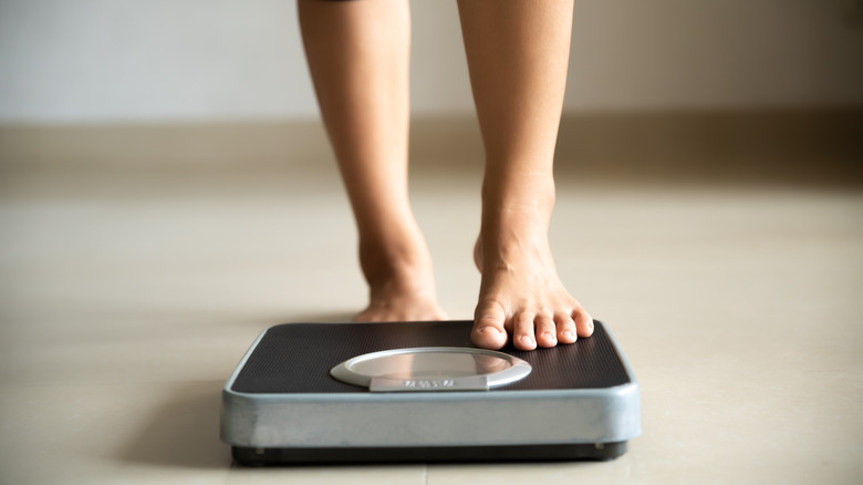 woman stepping on scale