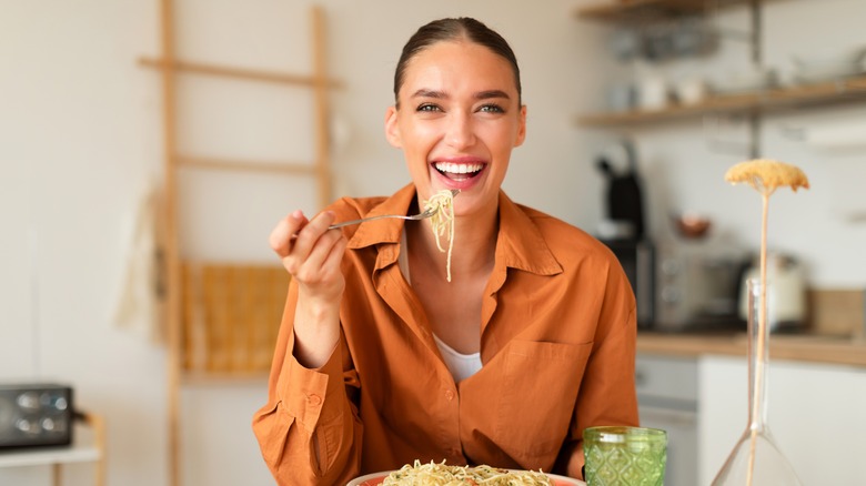 woman happily eating pasta