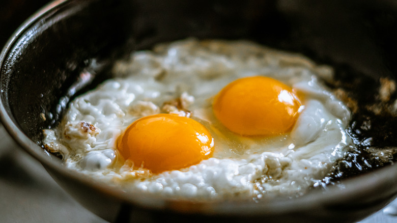 cooking fried eggs in skillet