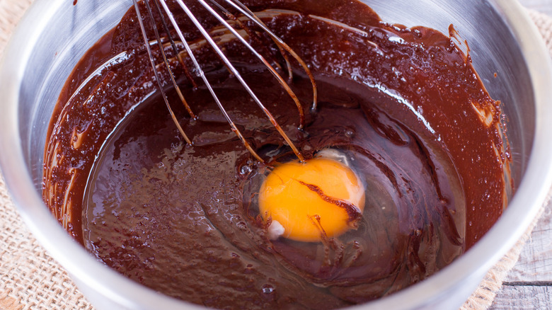 Bowl of brownie batter with egg