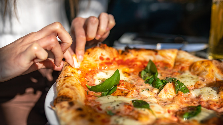 person eating Margherita pizza 