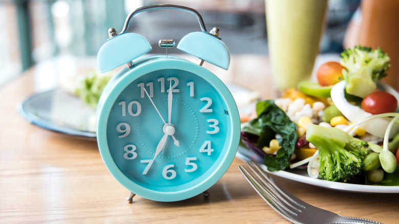 Clock beside a fork and salad 