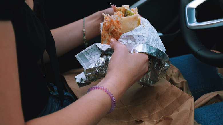 Woman eating a messy burrito 