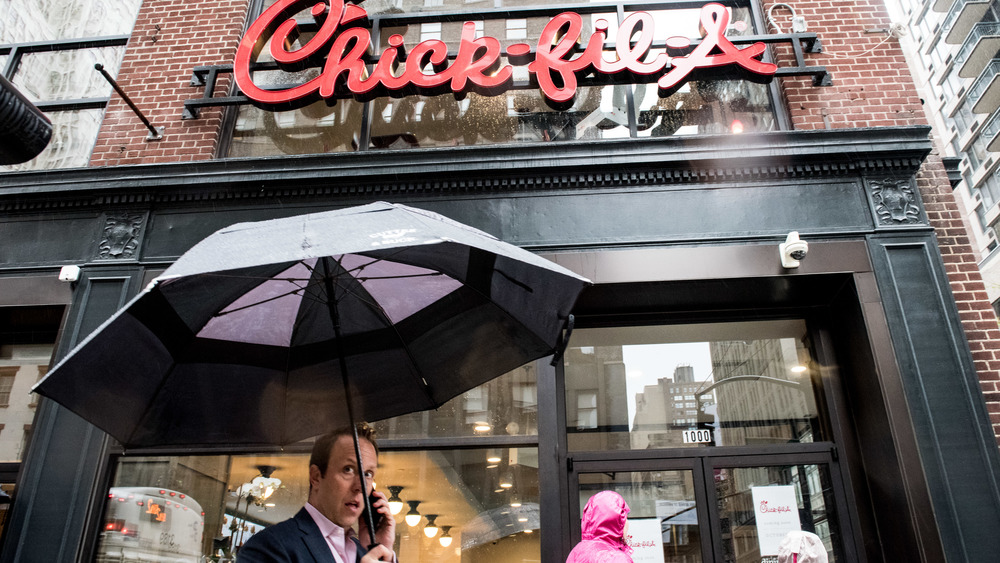 Chick-fil-A restaurant with man holding umbrella