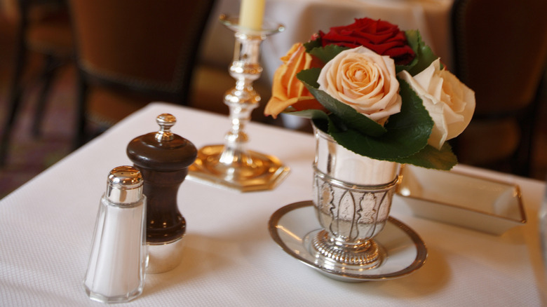 dinner table setting with fancy salt and pepper shakers at Michelin 3-star restaurant L'Ambroisie in Paris