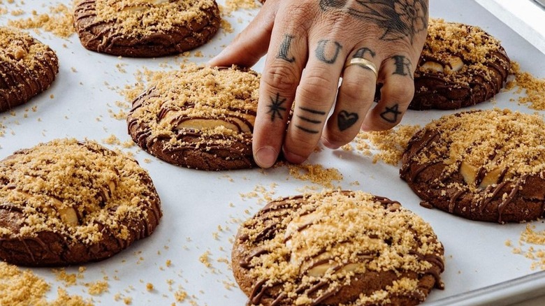 Tattooed hand touching cookie