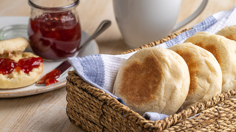 whole English muffins in basket and cut English muffin on plate with jam