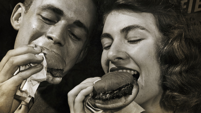 Young people eating burgers in 50s