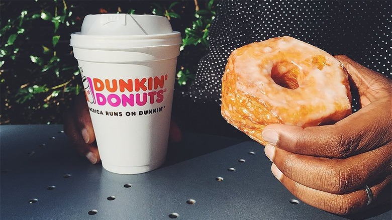 person holding doughnut and coffee