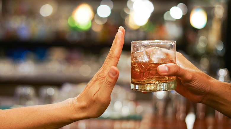 Hand blocking glass of liquor