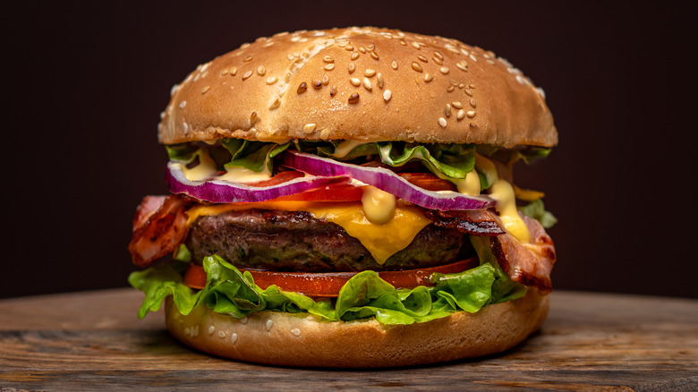 bacon cheeseburger on wood table