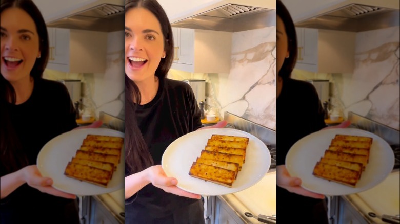 Katie Lee Biegel holding a plate of tofu