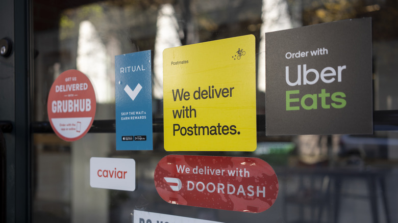 signs for various delivery apps on window