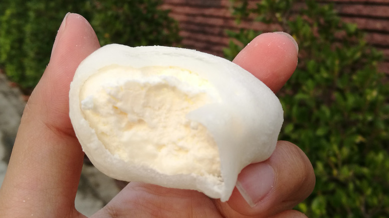 Hand holding vanilla mochi ice cream