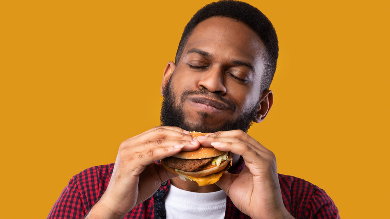 Person eating burger with hands