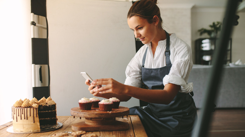 Woman taking a photo of a cake