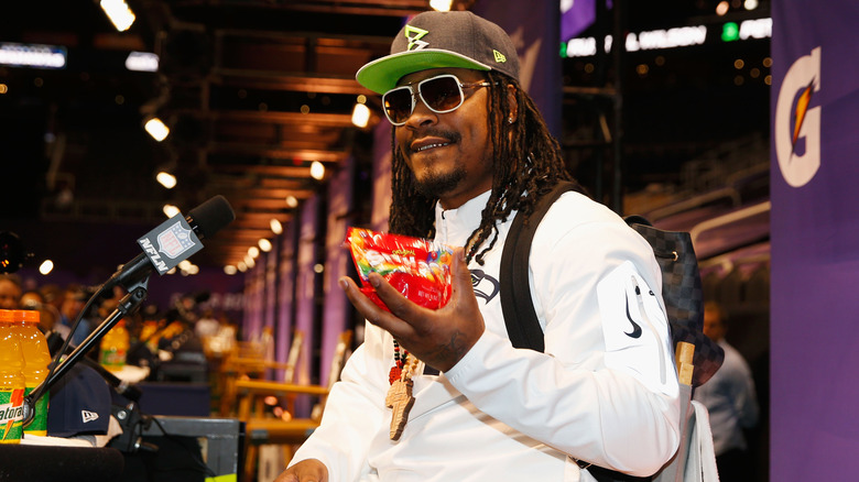 Marshawn Lynch holds Skittles during an interview