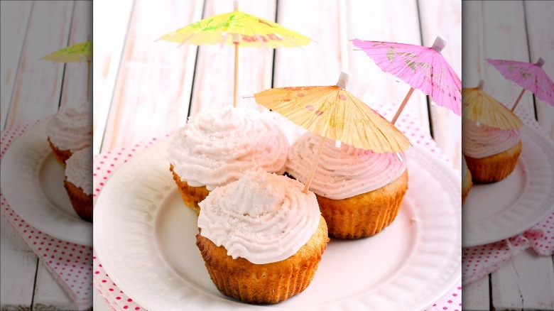 frosted cupcakes with cocktail umbrellas