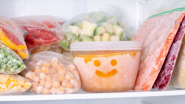 Foods in a freezer with a smiley face etched into one container
