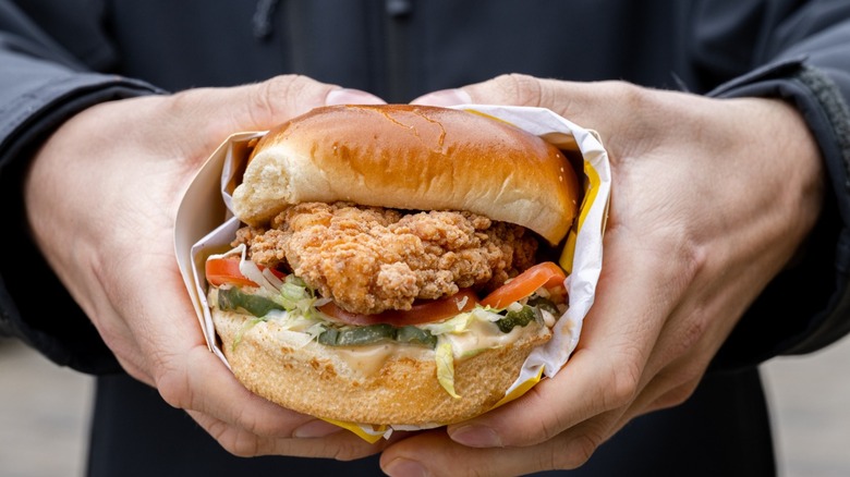 Person holding chicken sandwich