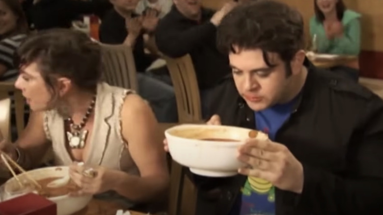 Adam Richman holds white bowl