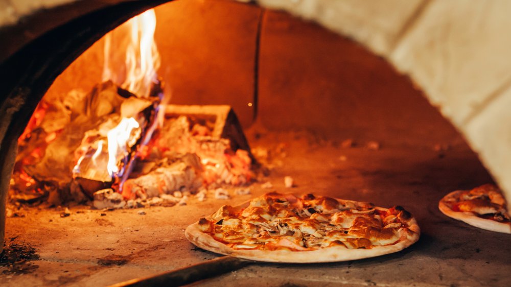 pizza going into a stone oven