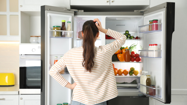 woman looking into freezer