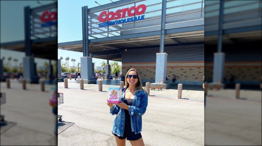 woman holding a 3-pound pack of Sweet Loren's vegan cookie dough outside of Costco