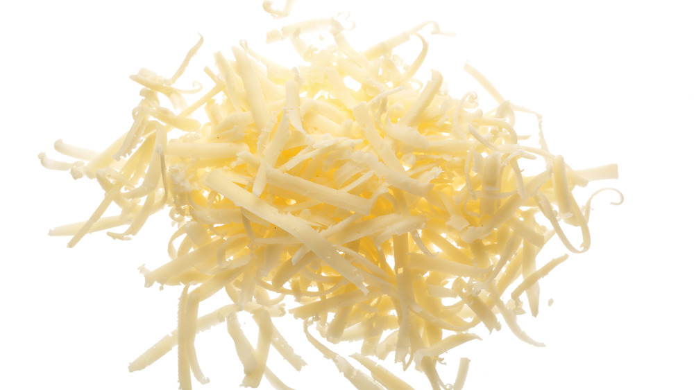 Grated parmesan cheese on white background